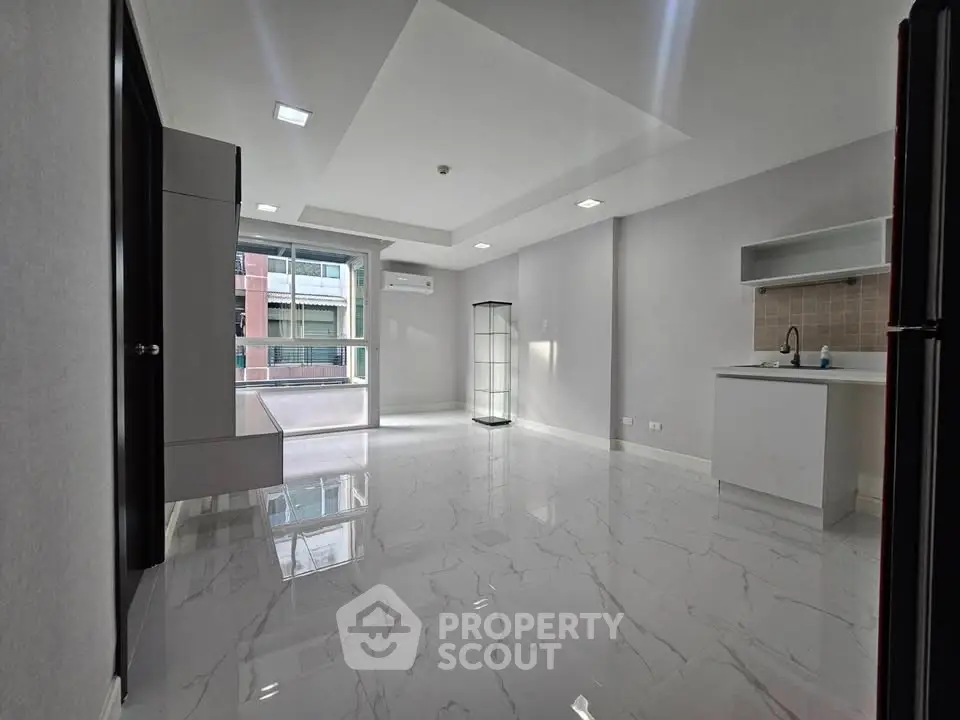 Modern open-layout living space with sleek flooring and ample natural light