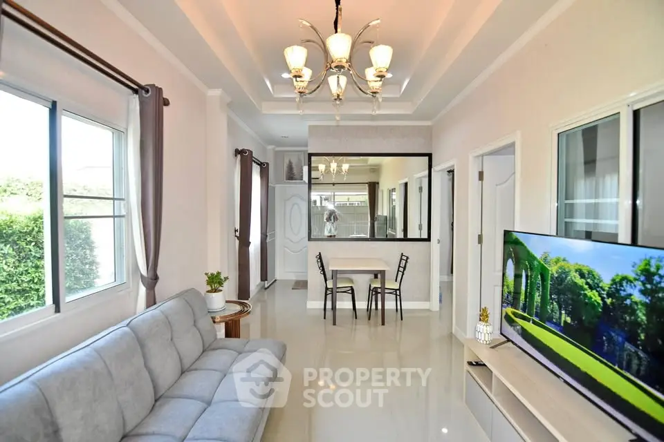 Modern living room with elegant chandelier and large windows