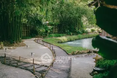 Serene garden with lush greenery and tranquil pond, perfect for relaxation.