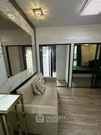 Modern living room with elegant decor and glass sliding doors leading to a bedroom.