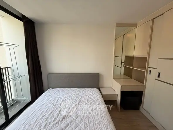 Modern bedroom with large window and built-in wardrobe, perfect for natural light lovers.