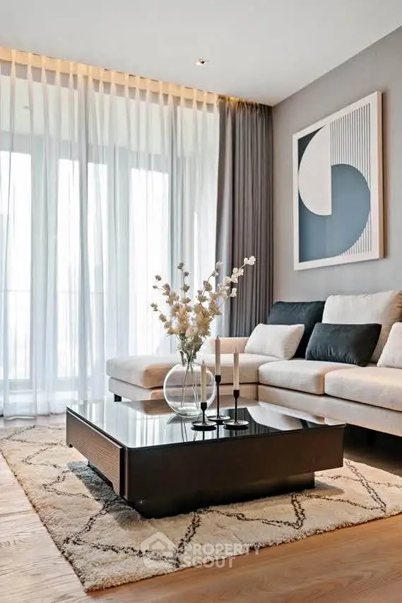 Elegant living room with modern decor, featuring a stylish sofa, chic coffee table, and large window draped with sheer curtains.