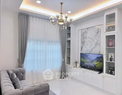 Luxurious living room with elegant chandelier and modern entertainment center