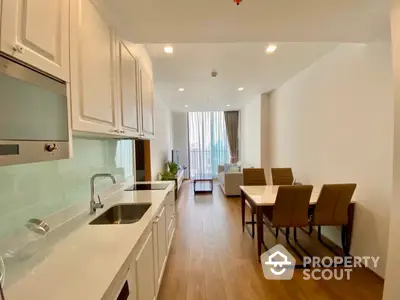 Spacious modern kitchen with sleek white cabinetry flows into a bright dining area, perfect for entertaining in a contemporary open-plan living space.