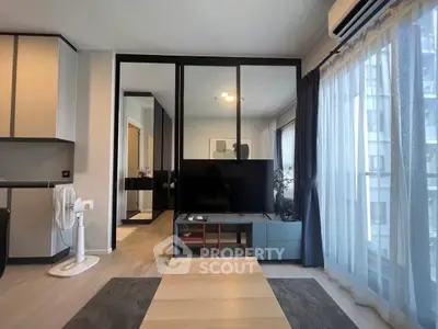 Modern living room with large windows and sleek furniture in a stylish apartment.