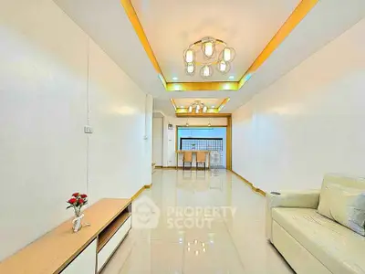 Spacious modern living room with elegant lighting and sleek furniture design.