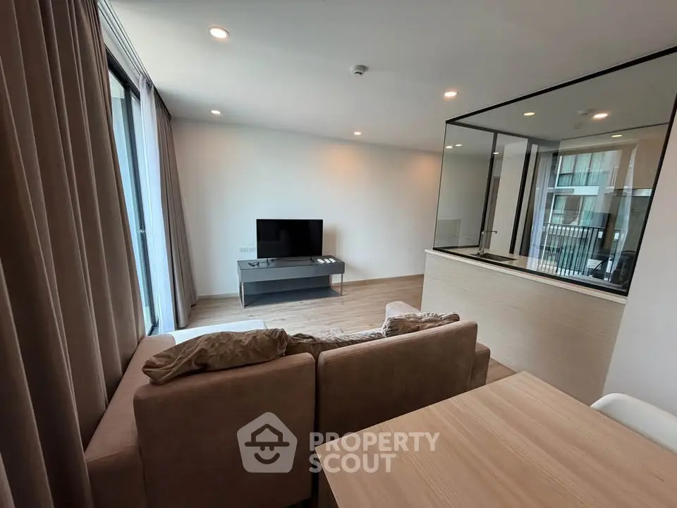 Modern living room with cozy sofa and large window in stylish apartment