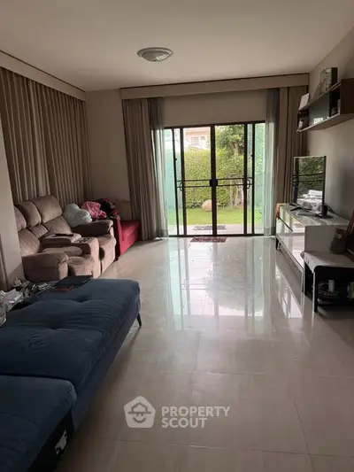 Spacious living room with modern furniture and garden view, perfect for relaxation and entertainment.