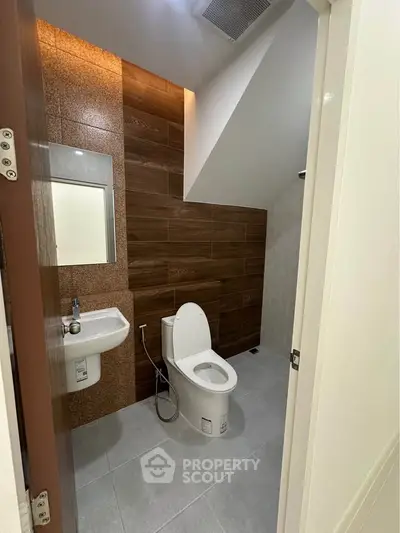 Modern bathroom with sleek design and wood accent wall