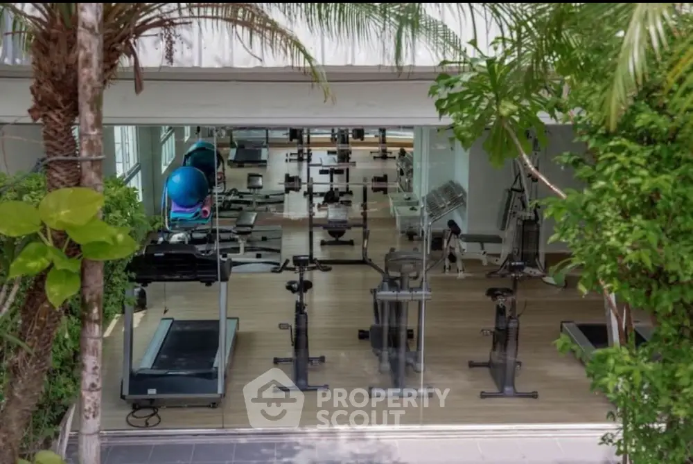Modern gym with state-of-the-art equipment and lush greenery view.