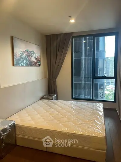 Modern bedroom with large window and city view, featuring a comfortable bed and stylish decor.