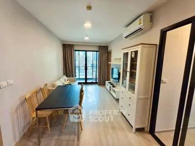 Modern living room with dining area and balcony access in a stylish apartment.
