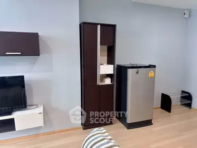 Modern living room with sleek storage and compact fridge, perfect for urban living.