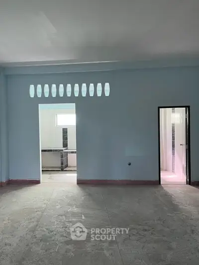 Spacious unfinished room with adjacent bathroom, featuring modern design and ample natural light.