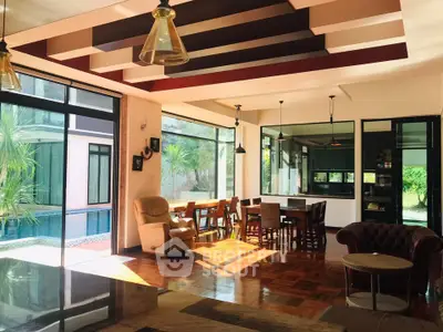 Spacious living room with pool view and elegant dining area