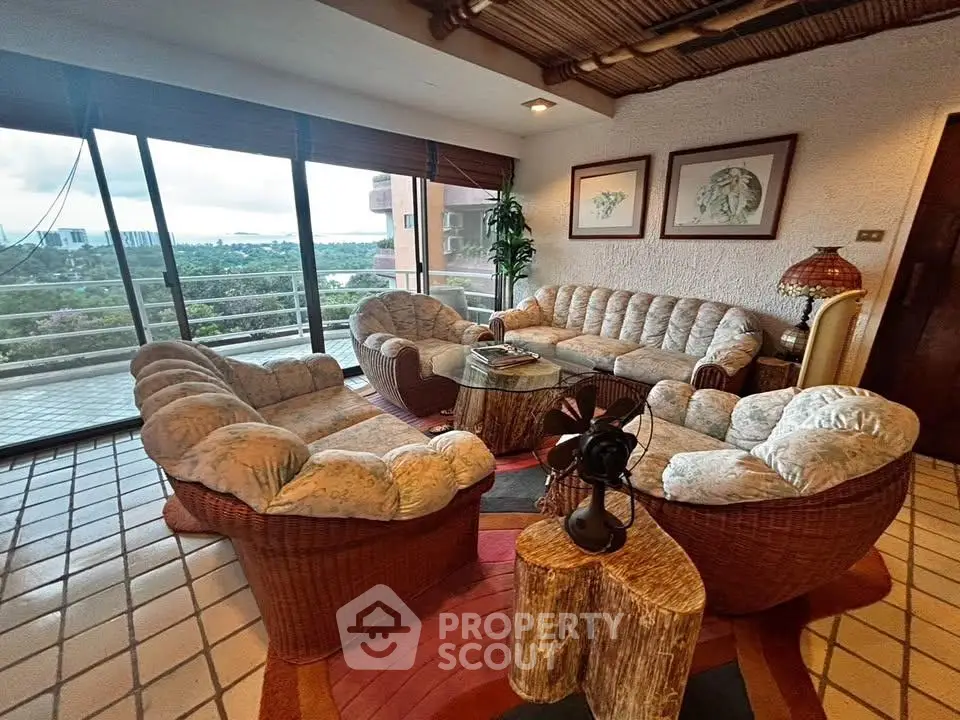 Spacious living room with cozy wicker furniture and panoramic balcony view