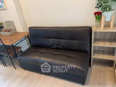 Cozy living room with stylish black leather sofa and wooden furniture