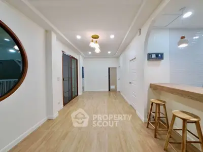 Spacious modern living area with wooden flooring and stylish lighting