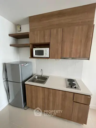 Modern compact kitchen with wooden cabinets and stainless steel appliances