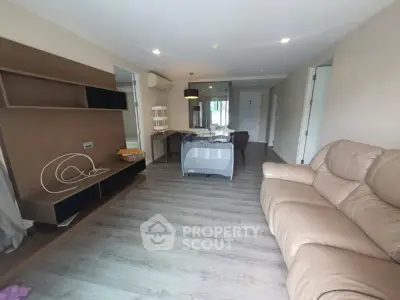 Spacious living room with modern furniture and wooden flooring in a stylish apartment.