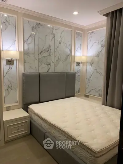Luxurious bedroom with elegant marble wall panels and plush grey headboard for a sophisticated ambiance.
