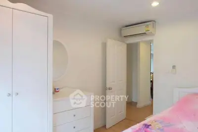 Cozy bedroom with white furniture and air conditioning, ideal for comfort and relaxation.