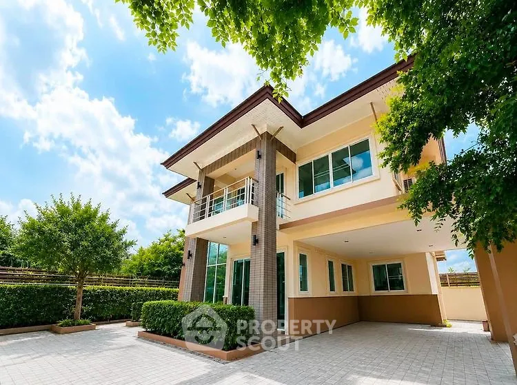 Stunning modern two-story house with lush greenery and spacious driveway.