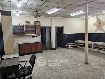 Spacious interior with potential for renovation, featuring open layout and ample lighting.