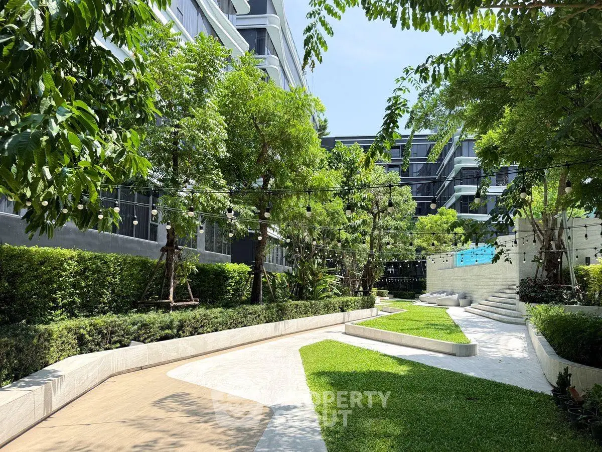 Luxurious garden area in modern residential complex with lush greenery and elegant pathways.