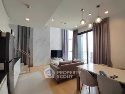 Modern living room with elegant decor and large windows offering natural light and city views.