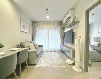 Modern living room with stylish decor and natural light, featuring a cozy sofa and wall-mounted TV.