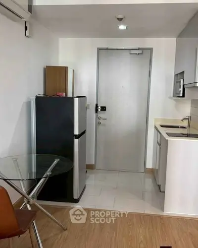 Modern compact kitchen with sleek appliances and dining area