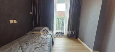 Cozy bedroom with single bed and balcony access, featuring modern decor and natural light.