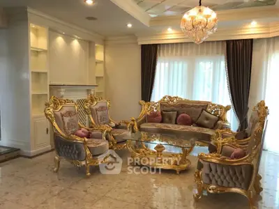 Luxurious living room with ornate gold furniture and elegant chandelier