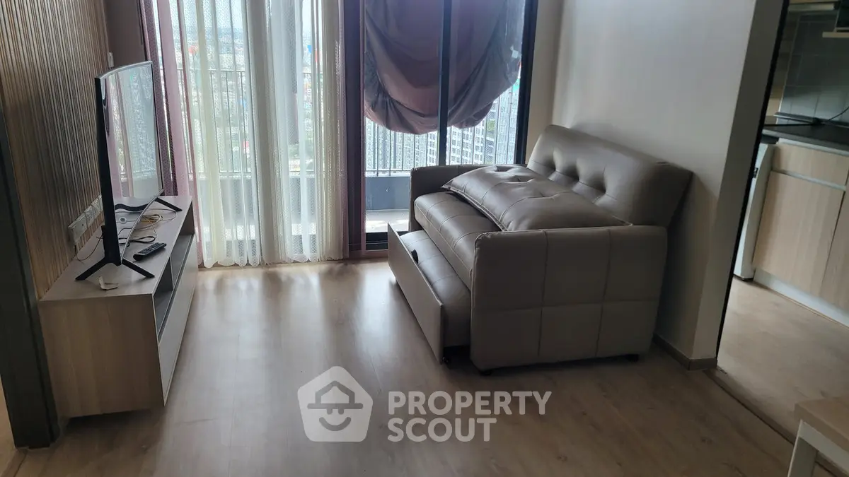 Modern living room with sofa bed and city view balcony, perfect for urban living.