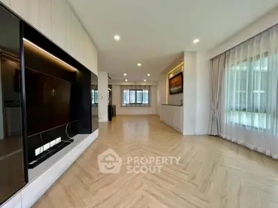Spacious modern living room with elegant flooring and large windows for natural light.