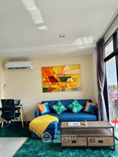Stylish living room with modern decor, vibrant artwork, and cozy seating area, perfect for relaxation.