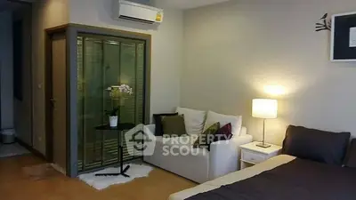 Cozy studio apartment with modern decor and comfortable seating area.