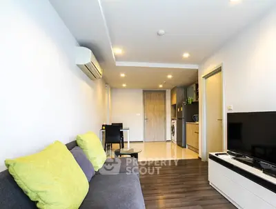 Modern living room with sleek furniture and open kitchen layout in a stylish apartment.