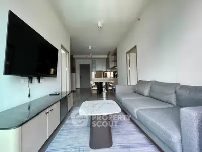 Modern living room with sleek furniture and large TV, perfect for contemporary urban living.