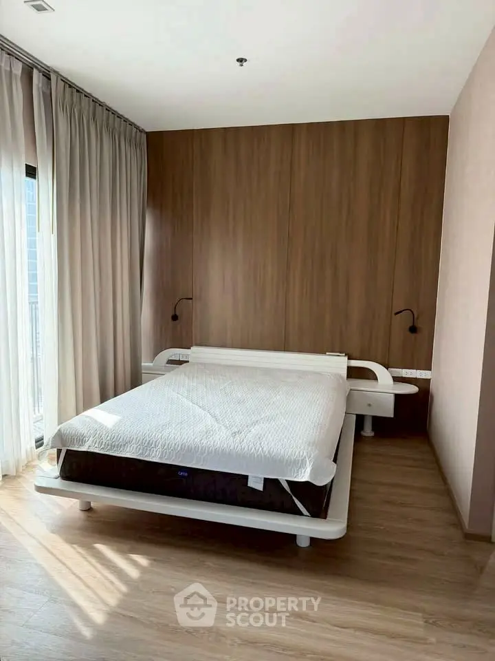 Modern bedroom with sleek design and wooden accents, featuring a stylish bed and floor-to-ceiling curtains.