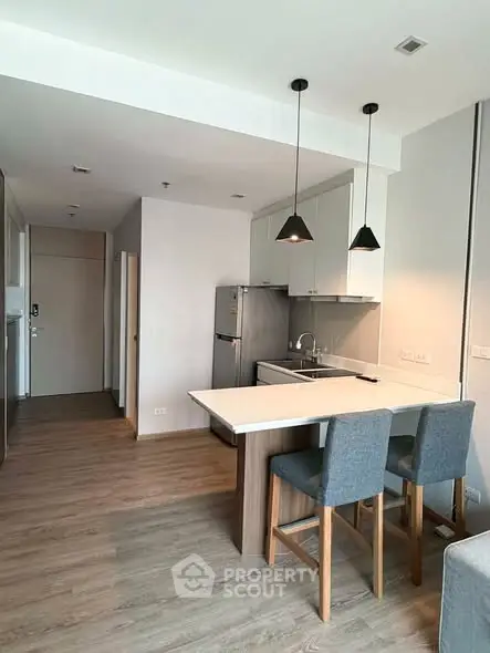 Modern kitchen with open layout and stylish bar seating in a contemporary apartment.