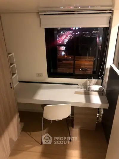 Modern study room with city view, featuring sleek desk and chair, perfect for productivity.