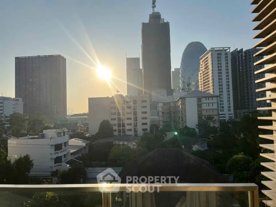 Stunning cityscape view from a balcony at sunrise, showcasing urban skyline.