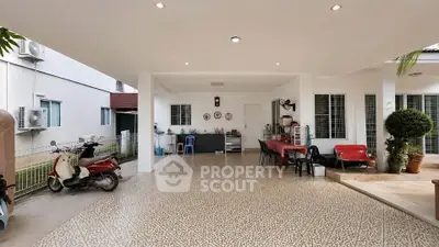 Spacious covered outdoor area with seating and scooter parking, ideal for gatherings.