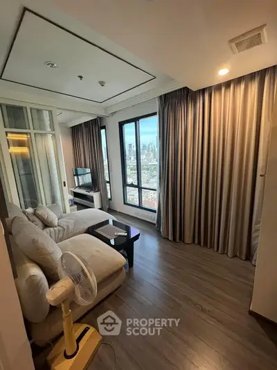 Modern living room with city view, featuring cozy seating and elegant decor in a high-rise apartment.