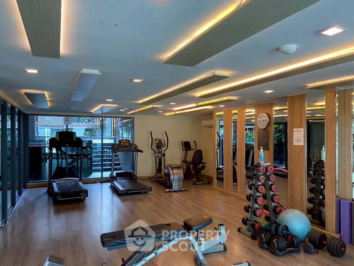 Modern gym with state-of-the-art equipment and sleek design in a luxury building.