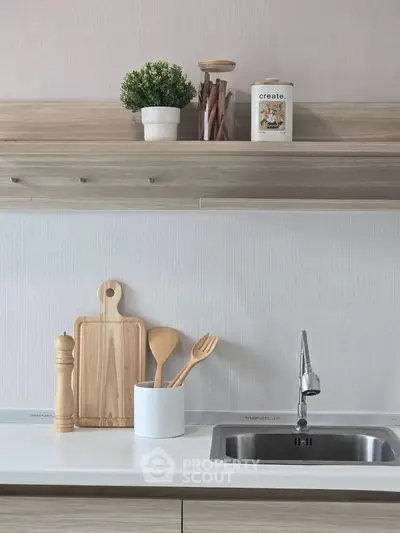 Modern kitchen with sleek countertop, stylish faucet, and wooden utensils, perfect for culinary enthusiasts.