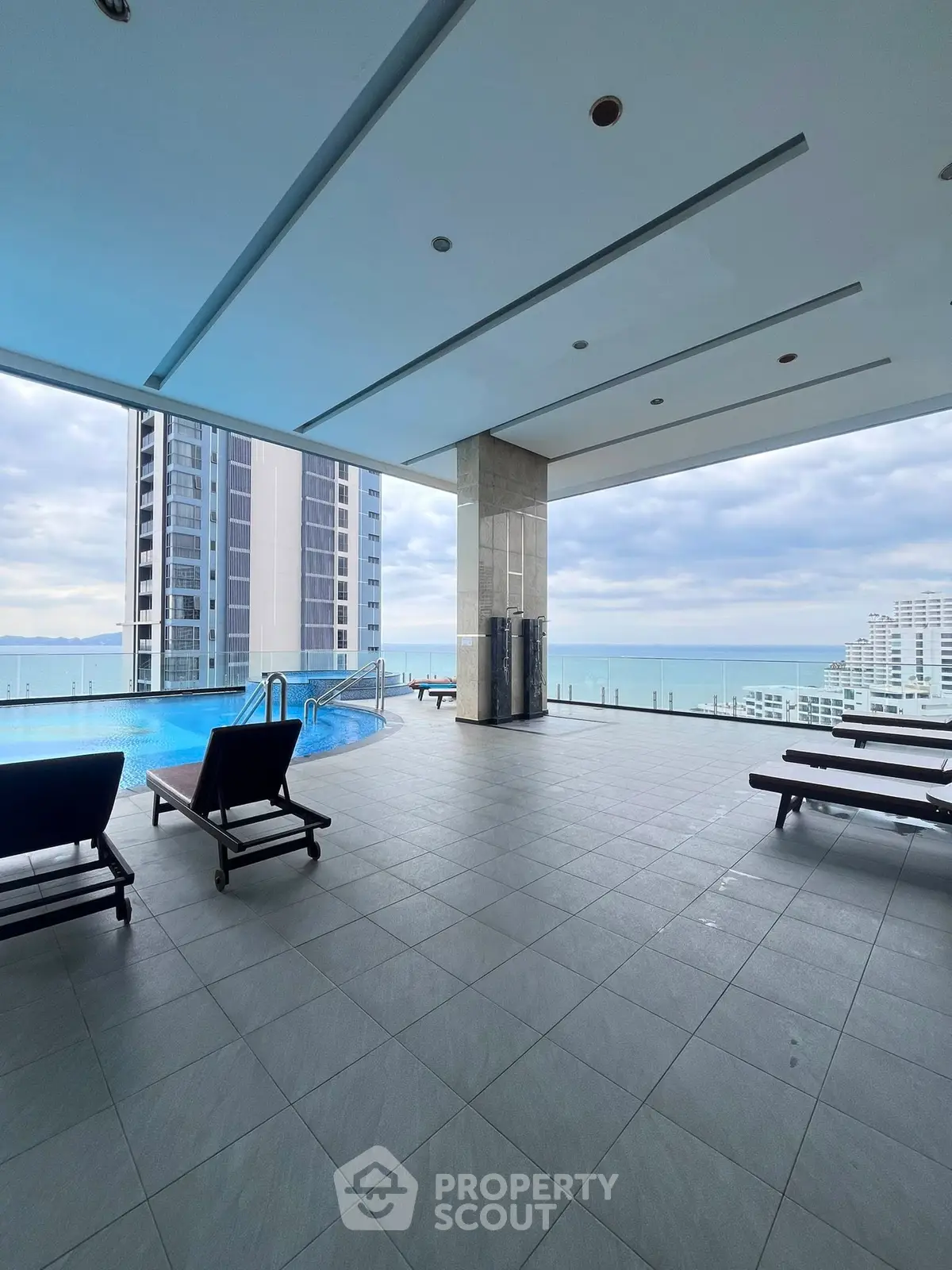 Luxurious rooftop pool with stunning ocean view and modern lounge chairs.