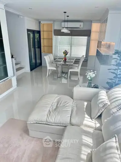 Elegant living room with plush sofa and dining area in modern open layout